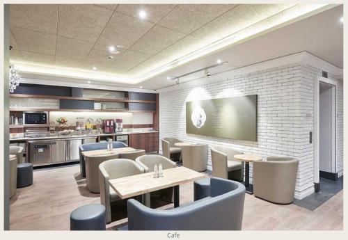 a restaurant with tables and chairs and a kitchen at Hotel Bencoolen at Hong Kong Street in Singapore