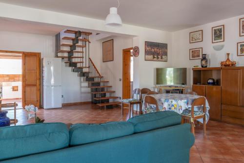 uma sala de estar com um sofá azul e uma mesa em Casa Margherita Cefalù - Villa con accesso privato al mare em Cefalù