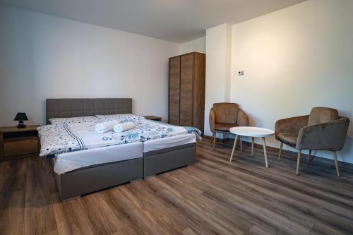 a bedroom with a bed and two chairs and a table at Chata Dolný Smokovec Správa TANAPu in Starý Smokovec
