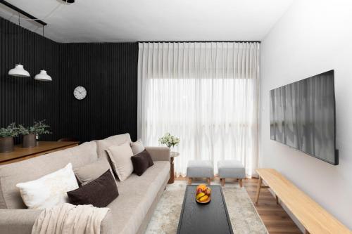 un soggiorno con divano e tavolo di AirTLV - Arlozorov Apartment's a Tel Aviv