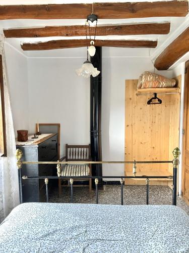 1 dormitorio con 1 cama y un banco en una habitación en Casa de Turisme Rural Riu Montsant, en Bellmunt de Ciurana