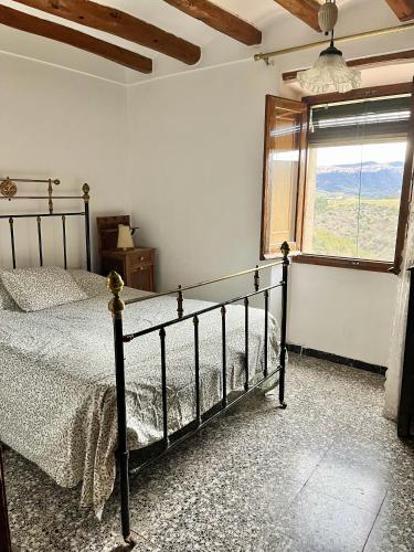 ein Schlafzimmer mit einem Bett in einem Zimmer mit einem Fenster in der Unterkunft Casa de Turisme Rural Riu Montsant in Bellmunt de Ciurana