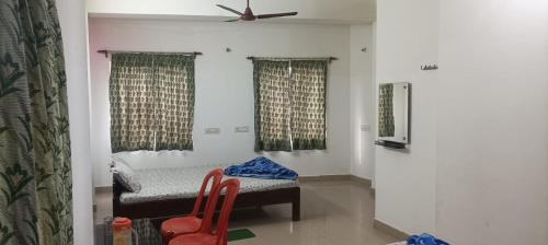 a room with a bed and two red chairs at Sandhya Guest House in Digha