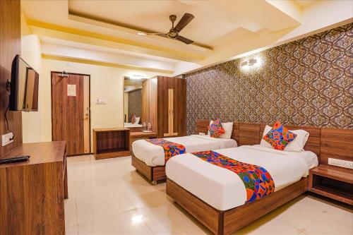 pokój hotelowy z 2 łóżkami i telewizorem w obiekcie FabHotel Ginger Suites w mieście Bengaluru