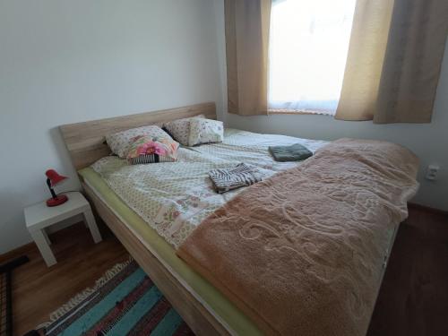 a unmade bed in a bedroom with a window at Na Piaskach Domek nad rzeką Agroturystyka in Narol