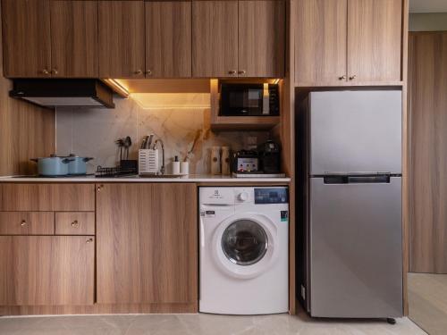 a kitchen with a refrigerator and a washing machine at Nysa Hotel Bangkok Sukhumvit 11 in Bangkok