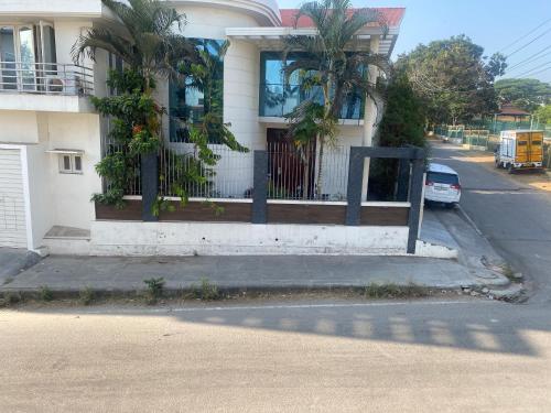 uma casa com um portão e um carro estacionado em frente em North Star Home Stay Mysore em Mysore
