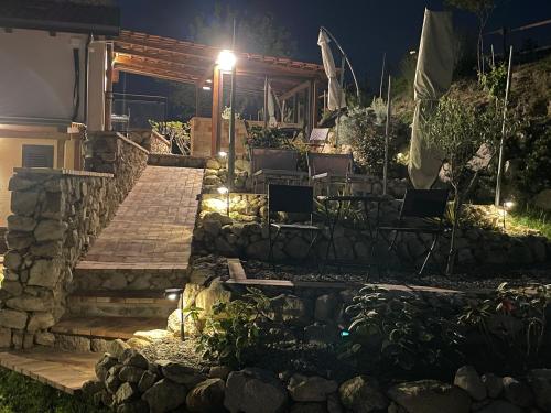 einen Garten in der Nacht mit einer Steinmauer in der Unterkunft Casa Natura 40 in Parghelia
