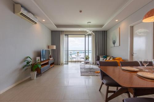 een woonkamer met een eettafel en een woonkamer bij Diamond Island Highfloor RiverView 8min to D1 in Ho Chi Minh-stad