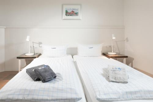 two beds with towels on top of them in a room at Luv in Juist