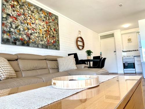 a living room with a couch and a painting on the wall at Location Location Vacation in Fremantle