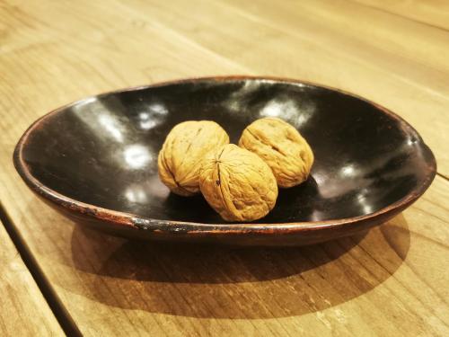 two walnuts in a bowl on a wooden table at B&B Le Noci in Ascoli Piceno