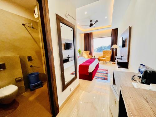 Habitación de hotel con baño y dormitorio en Hamshu Cafe & Stay, en Kota