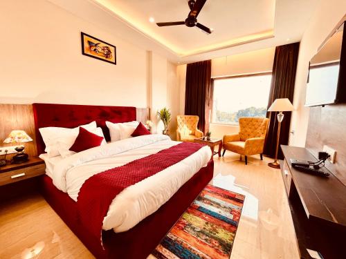 ein Hotelzimmer mit einem Bett und einem Wohnzimmer in der Unterkunft Hamshu Cafe & Stay in Kota