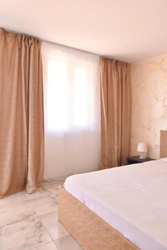 a bedroom with a white bed and a window at Vadul Chiquita in Vadu