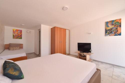 a hotel room with two beds and a television at Vadul Chiquita in Vadu