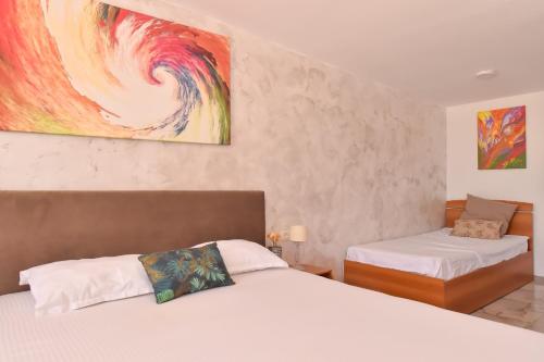 a bedroom with two beds and a painting on the wall at Vadul Chiquita in Vadu