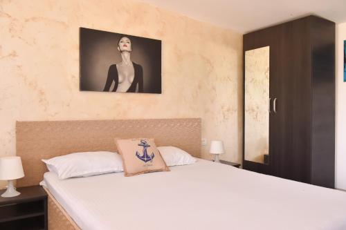 a bedroom with a bed and a picture of a woman at Vadul Chiquita in Vadu