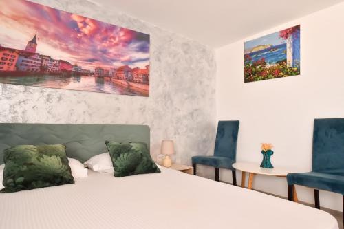 a bedroom with a bed and two blue chairs at Vadul Chiquita in Vadu