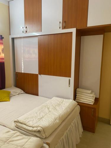 um quarto com uma cama e armários de madeira em North Star Home Stay Mysore em Mysore