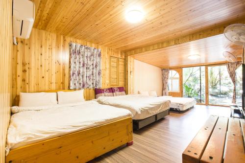 a bedroom with two beds and a wooden wall at Song Hua Ju B&B in Heping
