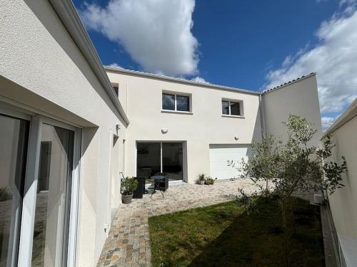 ein weißes Haus mit einer Terrasse davor in der Unterkunft Maison 4 CH proche de la mer in Aytré