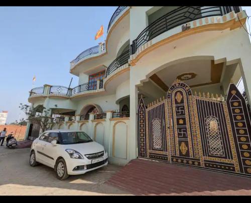 un coche blanco estacionado frente a un edificio en Ram Krishna Homestay, en Faizābād
