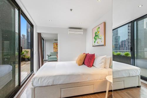 1 dormitorio con 1 cama extragrande y ventanas grandes en Superb 1-Bed CBD Pad with Private BBQ Area, en Melbourne