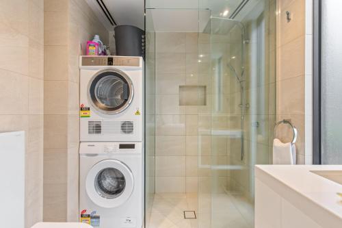 y baño con lavadora y secadora junto a una ducha. en Superb 1-Bed CBD Pad with Private BBQ Area, en Melbourne