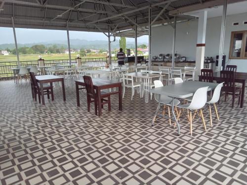 uma sala de jantar com mesas e cadeiras num piso de azulejo em LOSMEN 88 em Ratodena