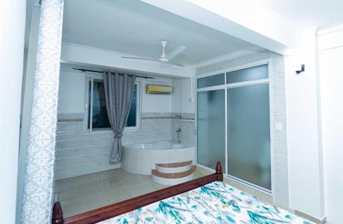 a bathroom with a tub and a shower at Kay's Place in Dar es Salaam