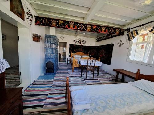 a bedroom with two beds and a table and a fireplace at Casa Felicia in Suceviţa
