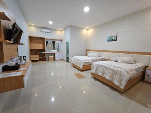 ein Hotelzimmer mit 2 Betten und einem TV in der Unterkunft LOSMEN 88 in Ratodena