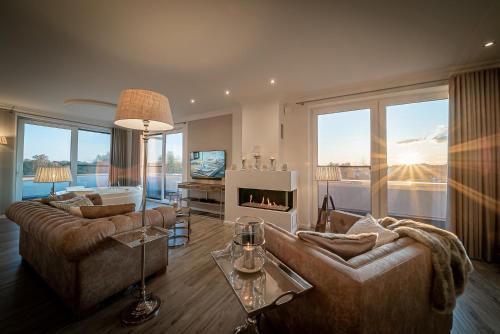sala de estar con 2 sofás y chimenea en Luxus Spa Penthouse Royal, en Göhren-Lebbin
