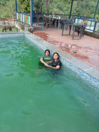 two children are swimming in a swimming pool at Maruti Paradise Resort in Udaipur