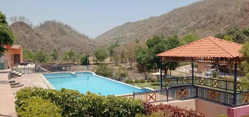 a swimming pool with a mountain in the background at Maruti Paradise Resort in Udaipur