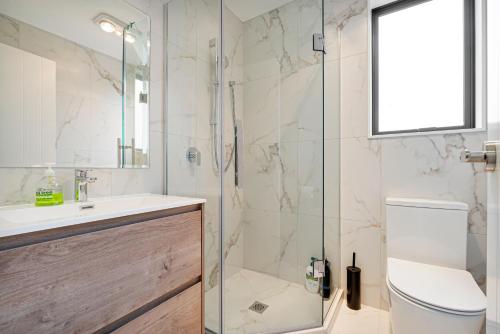 a bathroom with a shower and a toilet and a sink at Te Atatu Cozy Brand New Townhouse 5 in Auckland