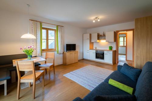 a living room with a blue couch and a table at Haus Hödlmoser in St. Wolfgang