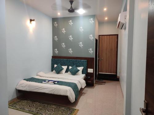 Hotel shivalay palace في Maheshwar: غرفة نوم مع سرير مع اللوح الأمامي الأخضر