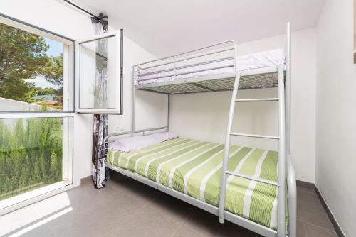 a bedroom with two bunk beds and a window at Domus Genti in Son Serra de Marina