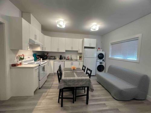 a kitchen with a table and chairs and a couch at Two Bedroom Suite Burnaby Metrotown in Burnaby