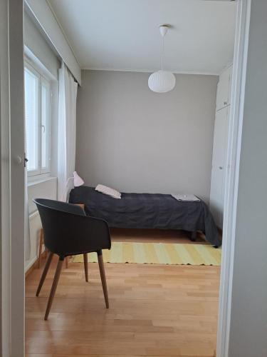 a bedroom with a bed and a chair in it at Tilava kolmio keskustassa in Ylivieska