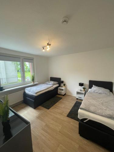 een slaapkamer met 2 bedden en een raam bij Moderne Wohnung in Uninähe in Maagdenburg