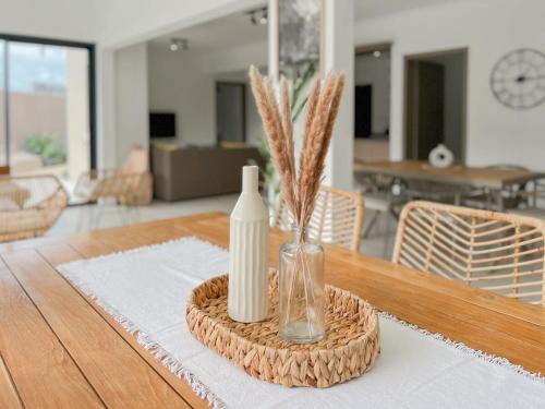 a table with a bottle and a vase with grass at Villa Celeste by Sealodge in Calodyne
