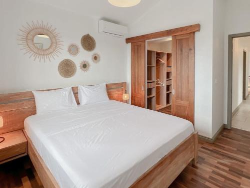 a bedroom with a white bed and a mirror at Villa Celeste by Sealodge in Calodyne