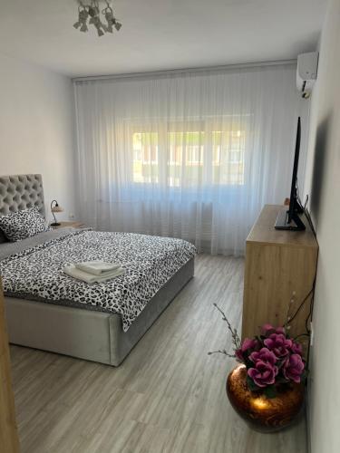 a bedroom with a bed and a vase of flowers at Apartament Tudor in Oradea
