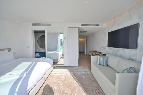 a hotel room with two beds and a couch at AKOYA HOTEL in Eilat