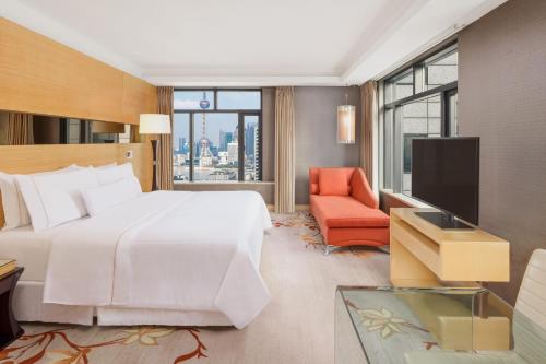 上海的住宿－上海威斯汀大饭店，卧室配有一张白色大床和一把椅子