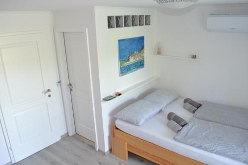 1 dormitorio con cama y pared blanca en Apartma na vasi en Sečovlje