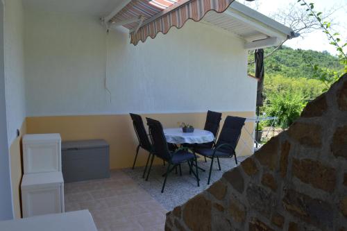 eine Terrasse mit einem Tisch und Stühlen in einem Zimmer in der Unterkunft Apartma na vasi in Sečovlje